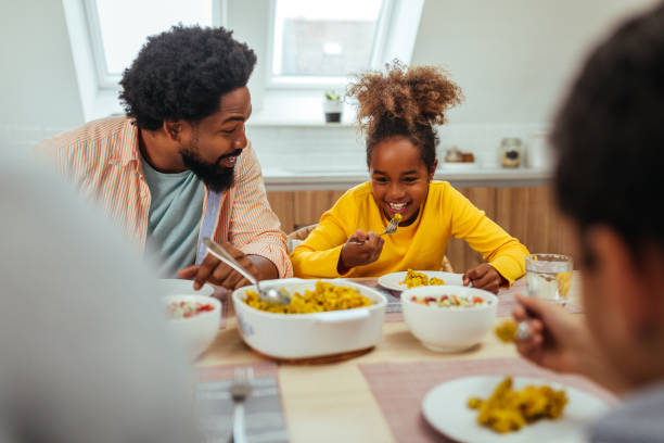 istock Cute afro family having lunch together at home 1299119497