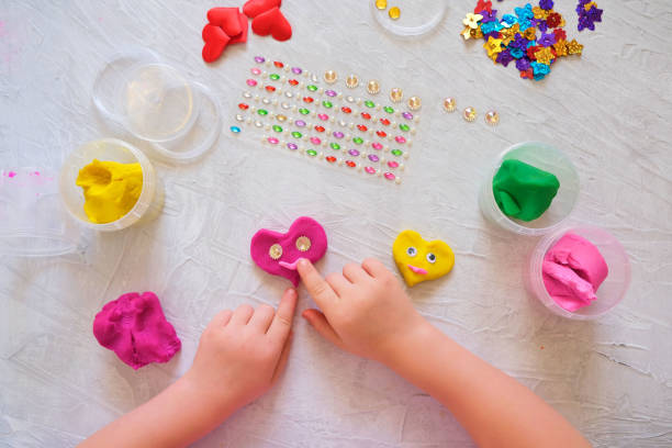 istock Child playing with colorful modeling clay and sculpting heart figure 1299121137