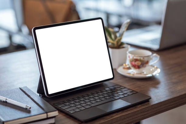 istock Mock up. blank screen digital tablet with office supplies on black wooden table. 1299122240