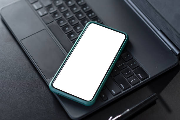 istock Top view of the desk with smartphone with blank screen in office. Mock up. copy space. 1299122320