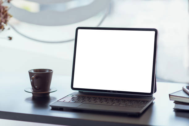 istock Mock up. blank screen digital tablet with office supplies on black wooden table. 1299122333