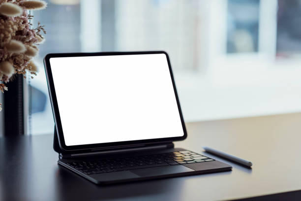 Mock up. blank screen digital tablet with office supplies on black wooden table.