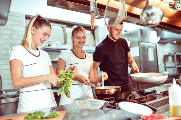 istock Smiling Female Cooks Working In Kitchen With Their Favorite Chef 1299123560
