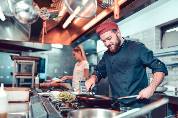 istock Smiling Chef Frying The Dinner In A Pan 1299123648