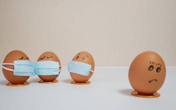 istock Eggs put on face mask - quarantine concept during Easter. Easter eggs in a medical mask. Self-isolation concept. 1299123997