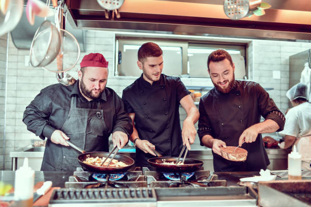 istock Focused Cooks Preparing Dinner For Restaurant Guests In Modern Kitchen 1299124251