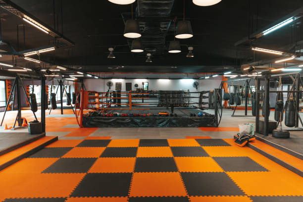 Boxing club Modern thai boxing gym in Thailand, boxing ring and punching bags visible in the image. kickboxing photos stock pictures, royalty-free photos & images