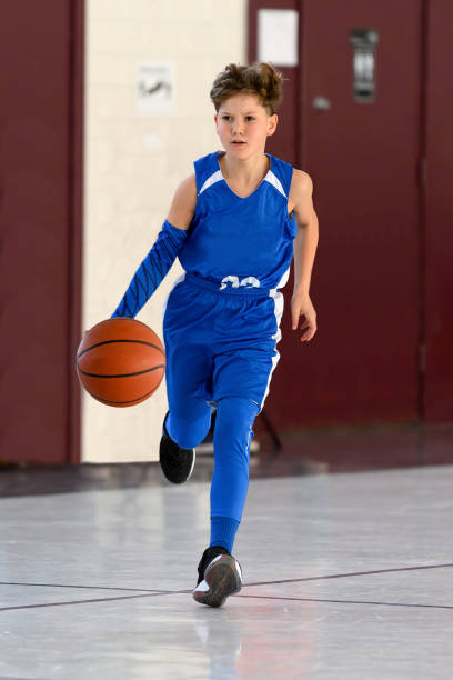 istock Young Athletic Boy Playing Basketball 1299125520