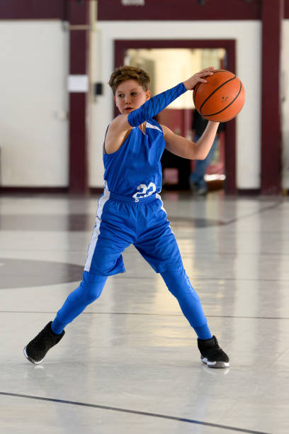 istock Young Athletic Boy Playing Basketball 1299125530