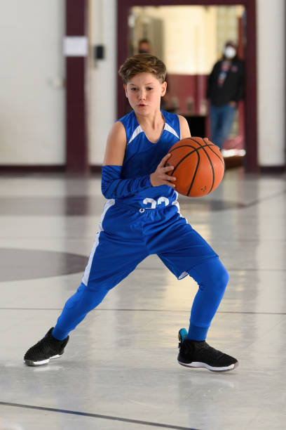 istock Young Athletic Boy Playing Basketball 1299125552