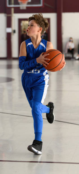 istock Young Athletic Boy Playing Basketball 1299125553