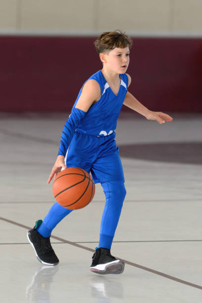 istock Young Athletic Boy Playing Basketball 1299125580