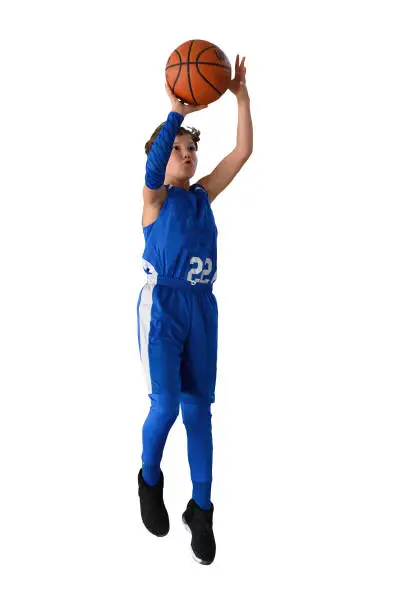 Young child (boy) athlete playing basketball in a youth football game