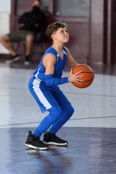 istock Young Athletic Boy Playing Basketball 1299125613