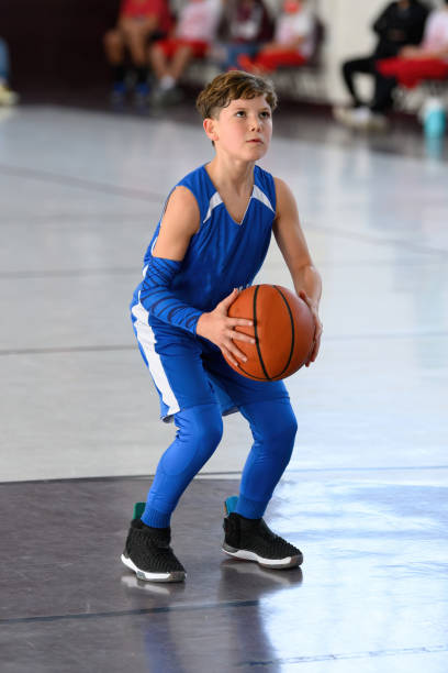 istock Young Athletic Boy Playing Basketball 1299125615