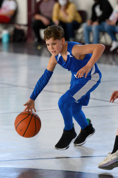 istock Young Athletic Boy Playing Basketball 1299125628