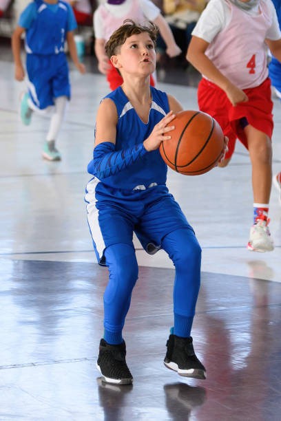 istock Young Athletic Boy Playing Basketball 1299125634