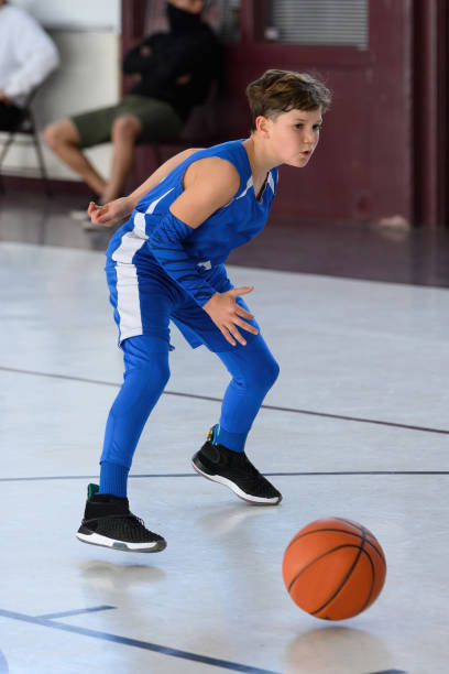 istock Young Athletic Boy Playing Basketball 1299126129
