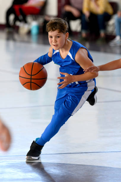 jovem atlético jogando basquete - basketball child dribbling basketball player - fotografias e filmes do acervo