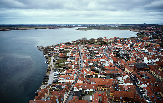 Drone shots from Kerteminde, Funen in Denmark. Kerteminde is a town located at the sea. The sun just rose and highlights a few rooftops with warm light