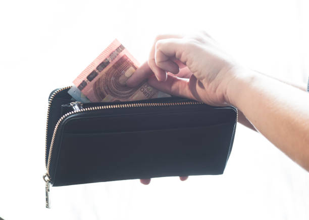 istock woman opening her purse for money 1299126793