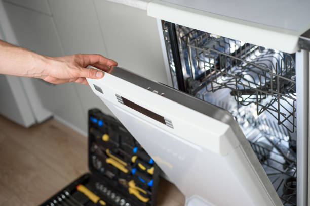 man repairing a dishwasher with tools - faulty imagens e fotografias de stock
