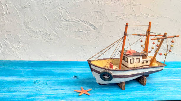 Fishing boat starfish with copy space on blue wooden background.