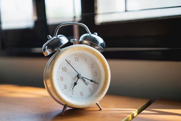 istock close up of alarm clock on wood office table 1299128544