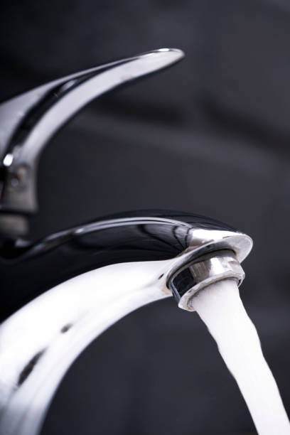 istock chrome faucet and running water 1299129313