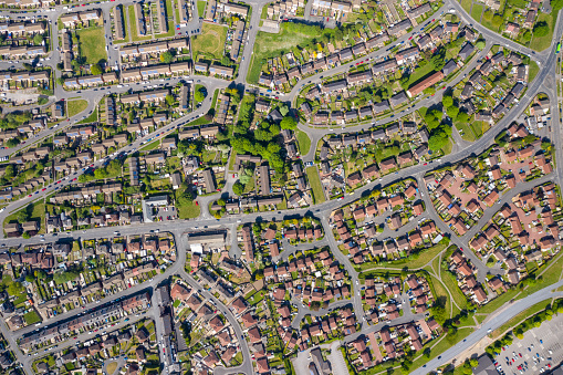 Top down aerial photo of the British town of Middleton in Leeds West Yorkshire showing typical suburban housing estates with rows of houses, taken on a bright sunny day using a drone.
