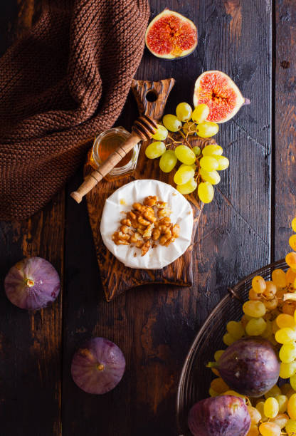 Vintage retro concept. Fresh grapes and figs on an old wooden background in retro style. Top view. Vintage retro concept. Fresh grapes and figs on an old wooden background in retro style. Top view. plate fig blue cheese cheese stock pictures, royalty-free photos & images