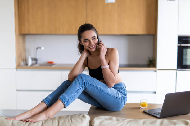 istock Happy excited woman talking on mobile phone in a kitchen 1299129637