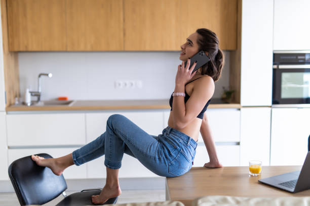 istock Happy excited woman talking on mobile phone in a kitchen 1299130492