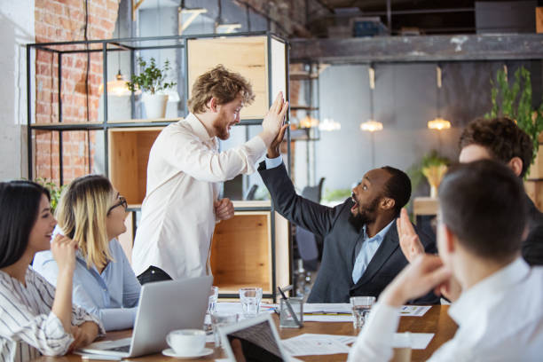 istock Diverse group of co-workers having casual discussion in office. Executives during friendly discussion, month reporting, creative meeting 1299132955