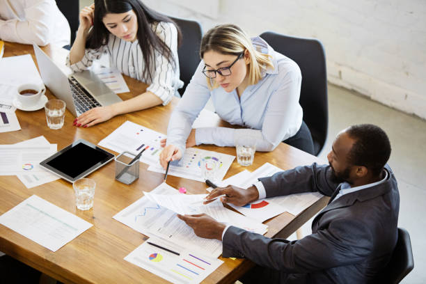 istock Diverse group of co-workers having casual discussion in office. Executives during friendly discussion, month reporting, creative meeting. Top view. 1299133006