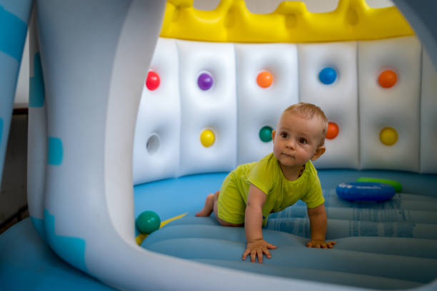 istock Child on colorful playground trampoline 1299133264