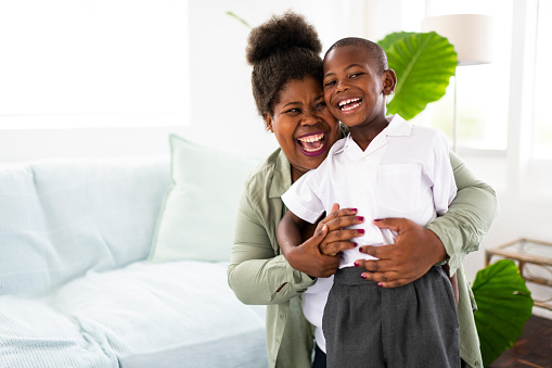 Portrait of smiling happy African mother and son in new school uniform