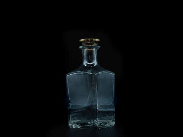 istock Empty glass bottle closed with big golden round cork isolated on a black background. 1299133665