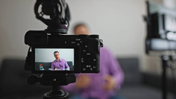 istock Handsome man recording his videoblog at home. 1299136641