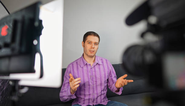 istock Handsome man recording his videoblog at home. 1299136654