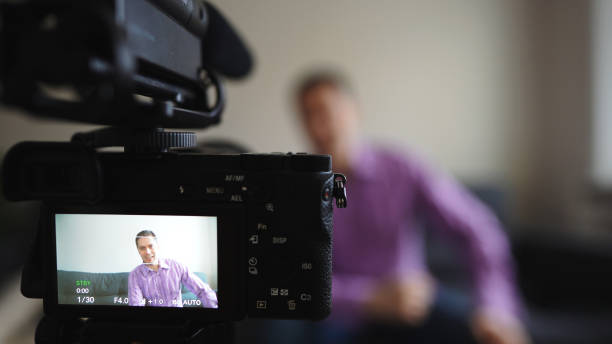 istock Handsome man recording his videoblog at home. 1299136659