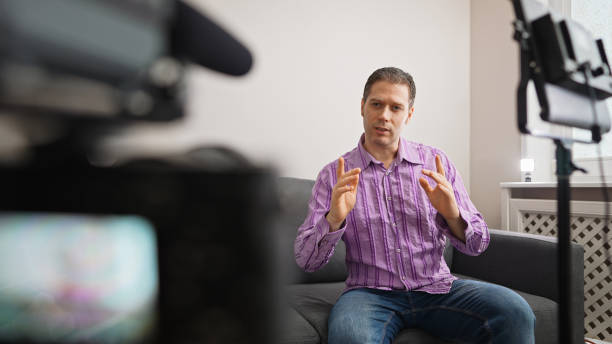 istock Handsome man recording his videoblog at home. 1299136669