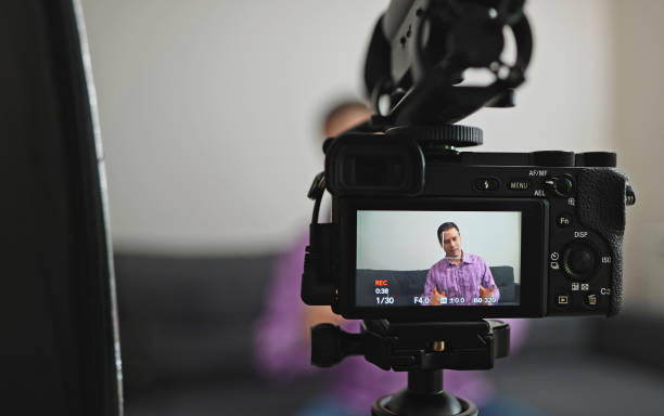 istock Handsome man recording his videoblog at home. 1299136675