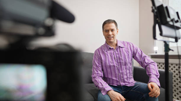istock Handsome man recording his videoblog at home. 1299136679