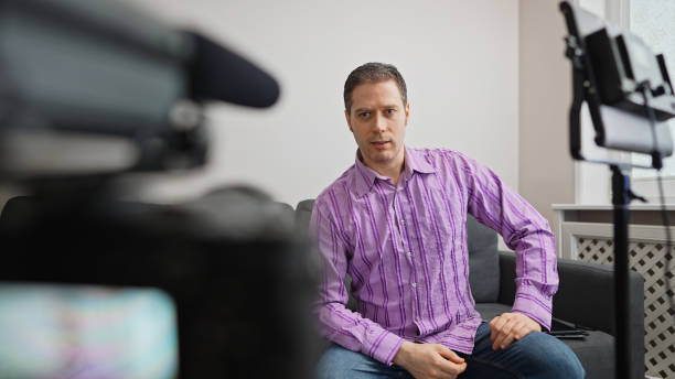 istock Handsome man recording his videoblog at home. 1299136710