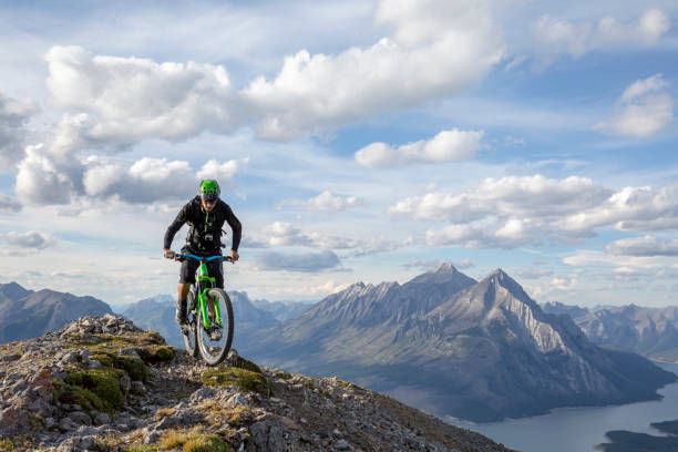 Mountain biker rides along mountain ridge in the morning