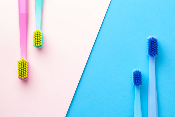 novas escovas de dentes em papel rosa e azul - toothbrush plastic multi colored hygiene - fotografias e filmes do acervo