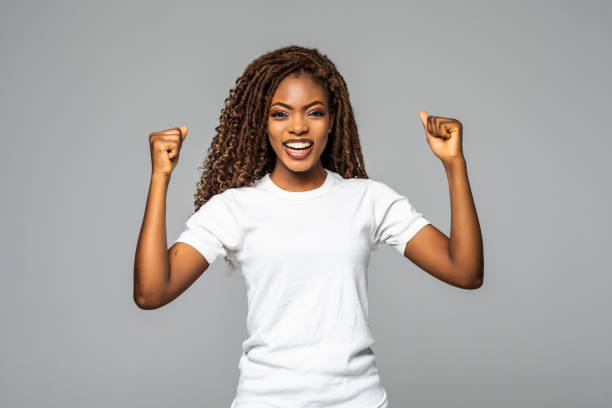 istock Happy african woman with raised arms isolated on white background 1299140865