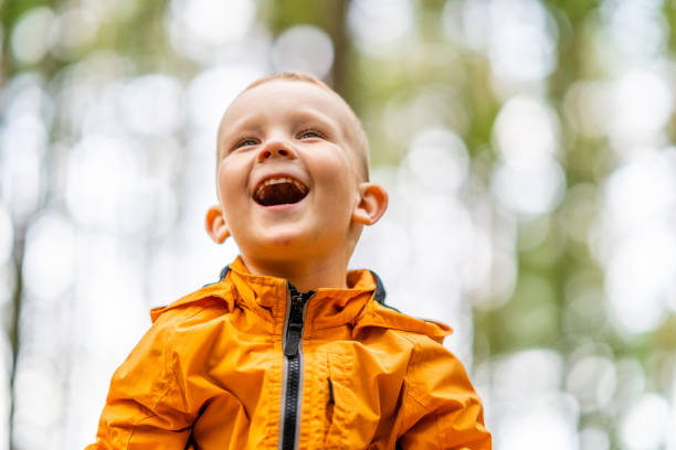 istock Young Caucasian Kid with Blond Hair Laughs, Photo with Copy Space 1299143451