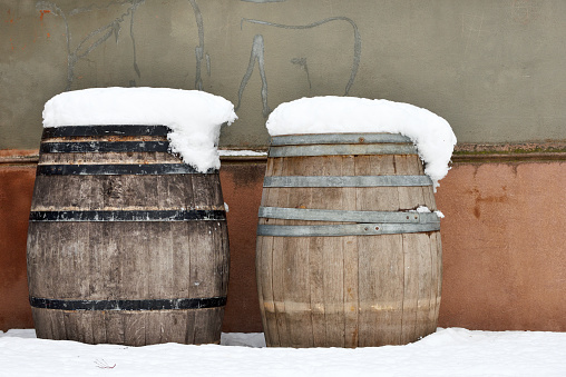Two old wood barrels covered by white snow